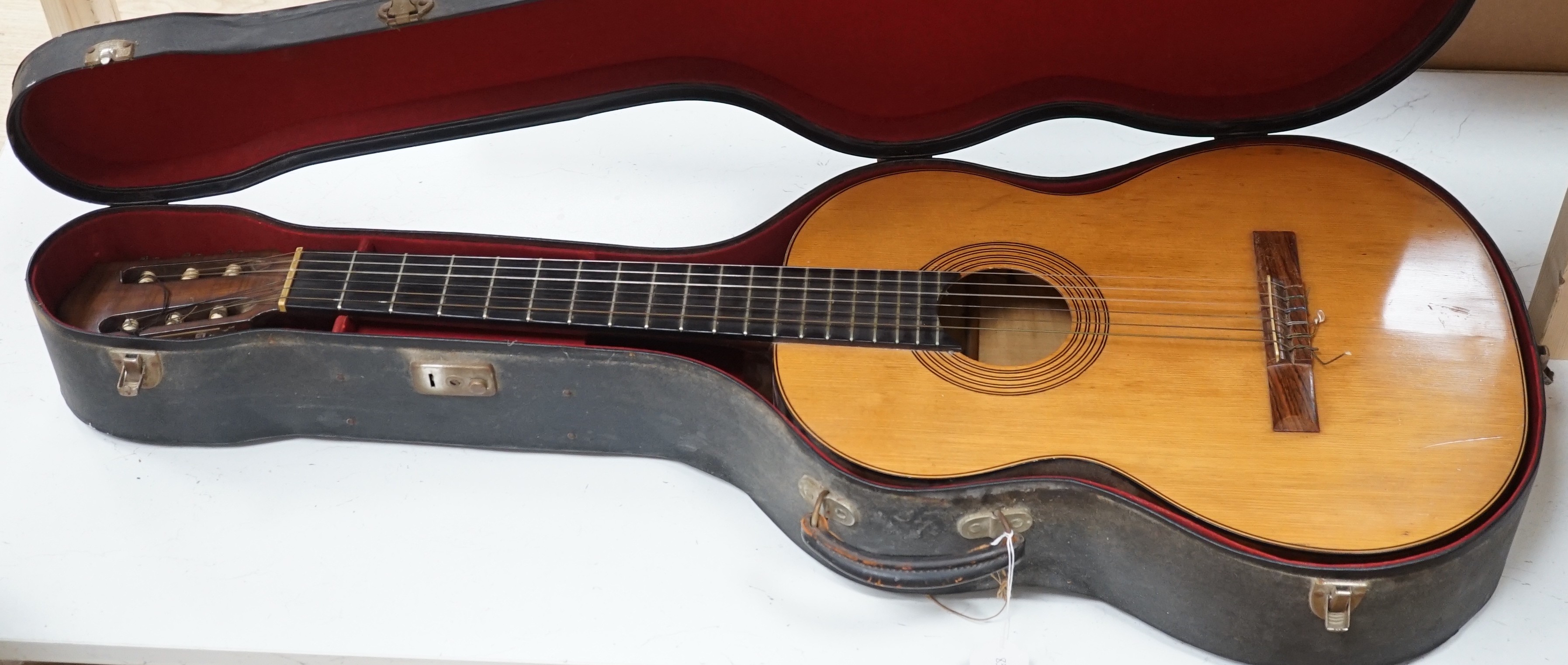A Harald Petersen classical concert guitar, paper label interior, with hard case. Length of back 49cm excluding button